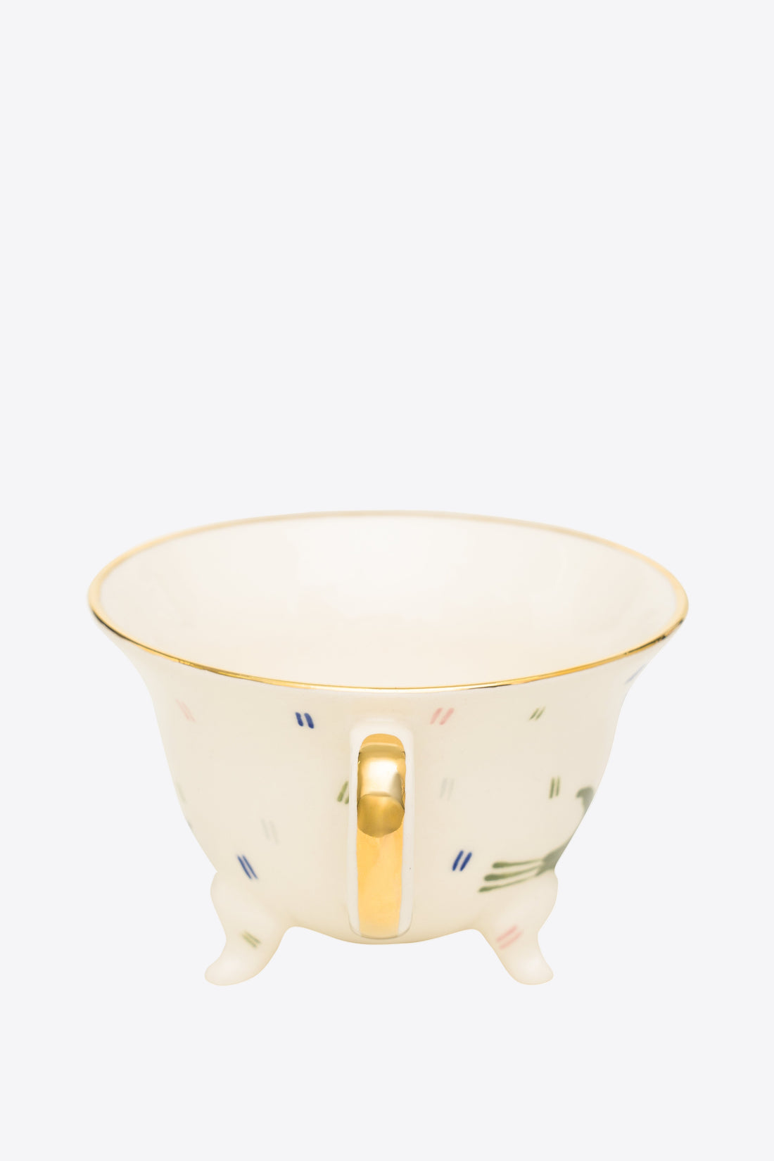Ceramic footed cup with gold handle on a white background