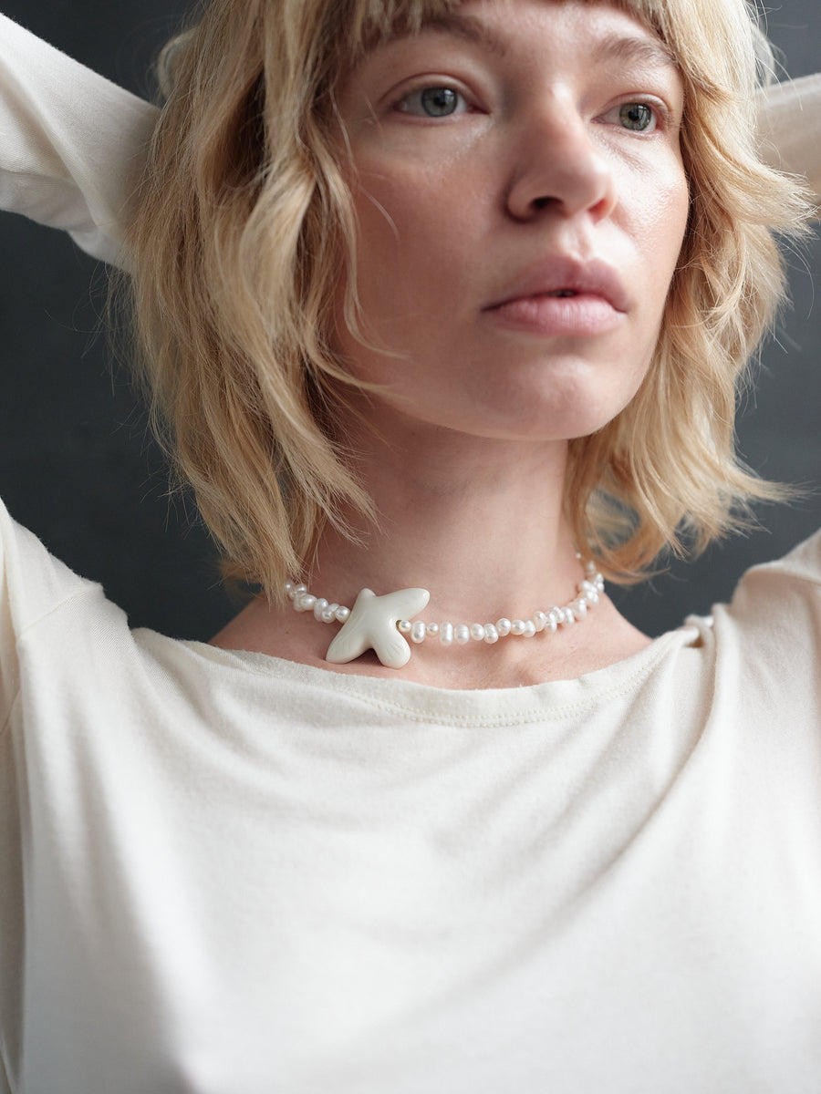 Myrni necklace with ear-shaped pearls and a porcelain bird
