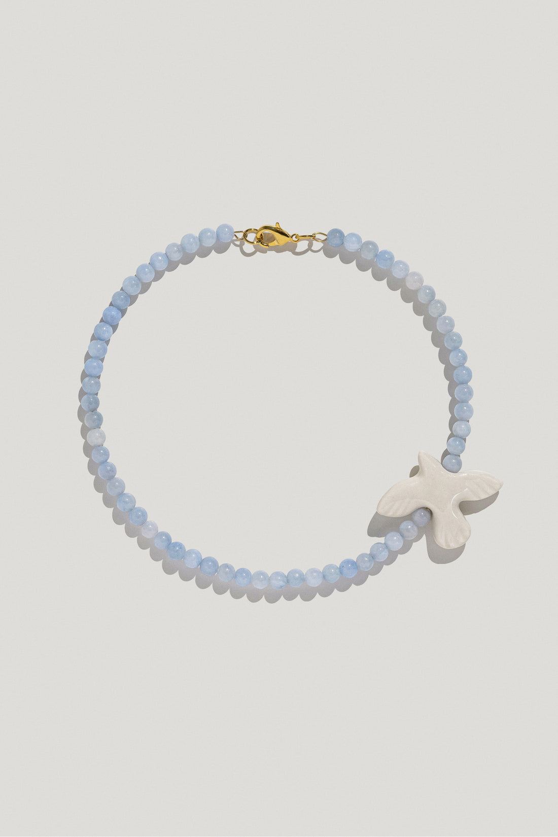 Myrni necklace with blue quartz and a porcelain bird