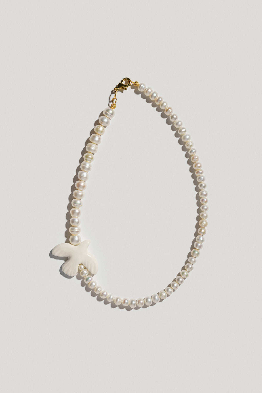 Myrni necklace with double-sized pearls and a porcelain bird