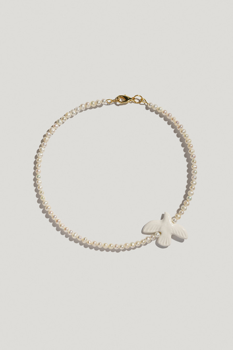 Myrni necklace with small-sized pearls and a porcelain bird