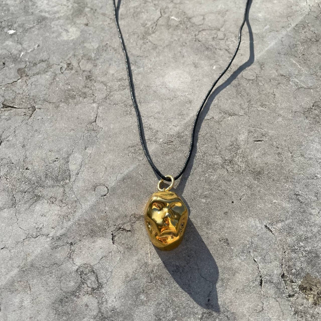 [P A M F I R]  small gold plated porcelain mask pendant on a cord