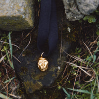 [P A M F I R]  small gold plated porcelain mask pendant on a cord