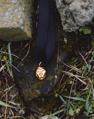 [P A M F I R]  small gold plated porcelain mask pendant on a cord