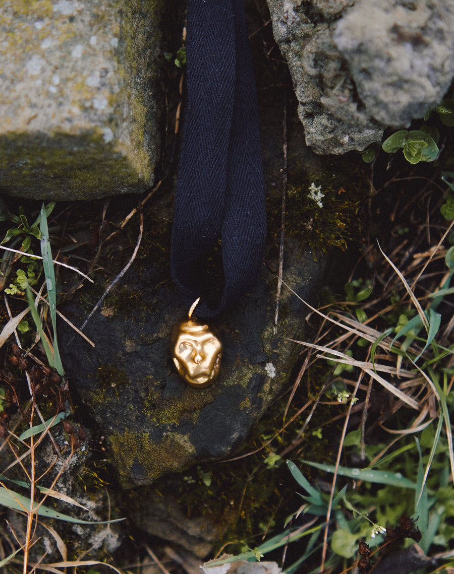 [P A M F I R]  small gold plated porcelain mask pendant on a cord