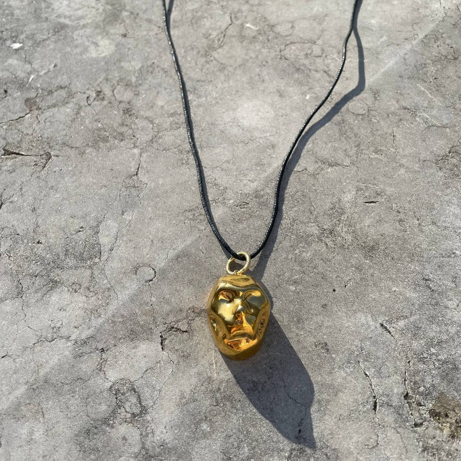 [P A M F I R]  small gold plated porcelain mask pendant on a cord