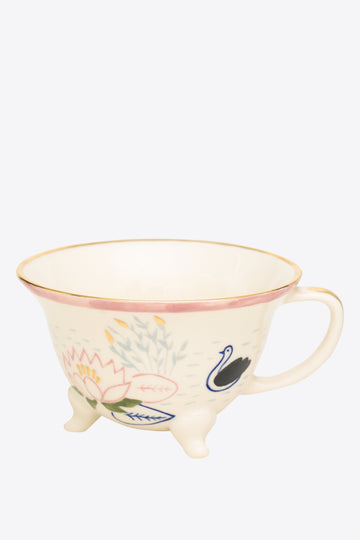 Ceramic cup with floral and swan design on a grey background