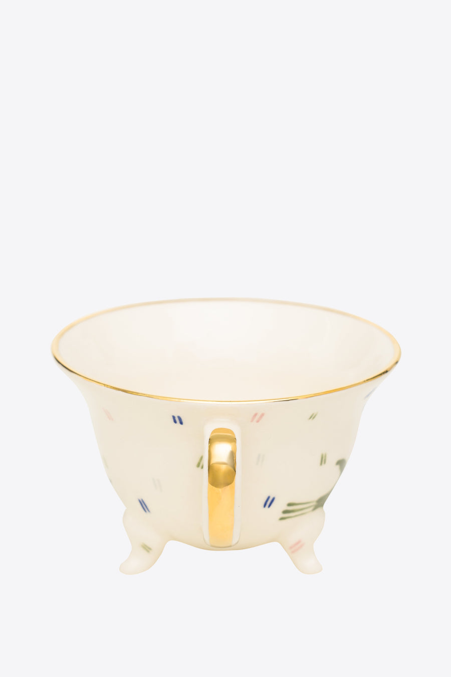 Ceramic footed cup with gold handle on a white background